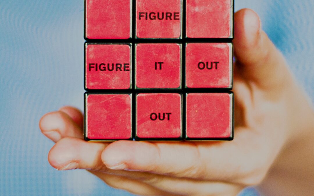 Hand holding a Rubi's cube that says "Figure It Out"