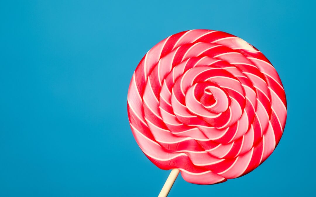 Red and pink striped lollipop on a turquoise background