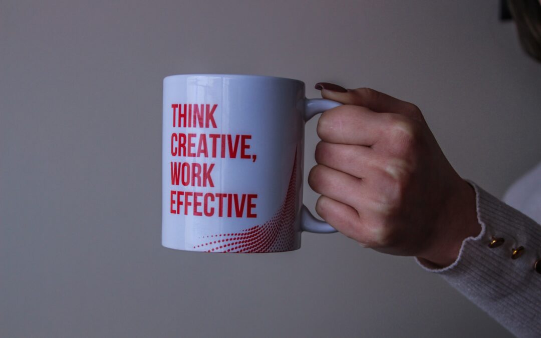 White coffee mug with "Think Creative. Work Effective" written in red block letters