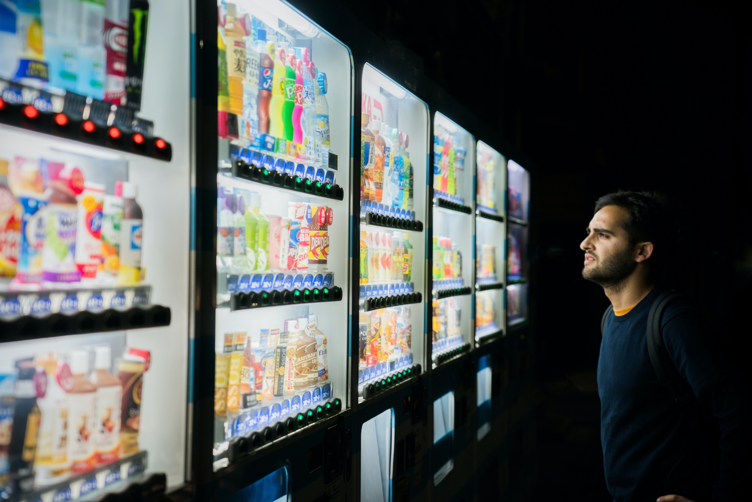 Man looking at a vending machine full of food