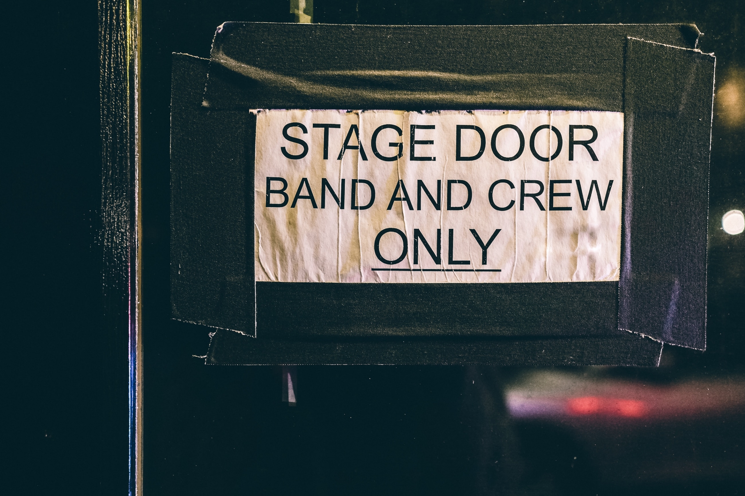 Sign taped to a door that reads "Stage Door. Band and Crew Only"