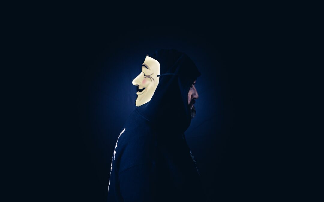 Person dressed in black, wearing a mask on the back of his head