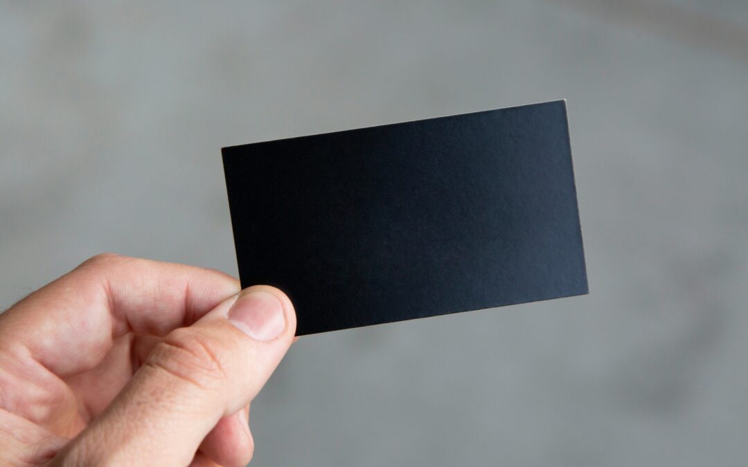 Hand holding a blank black business card