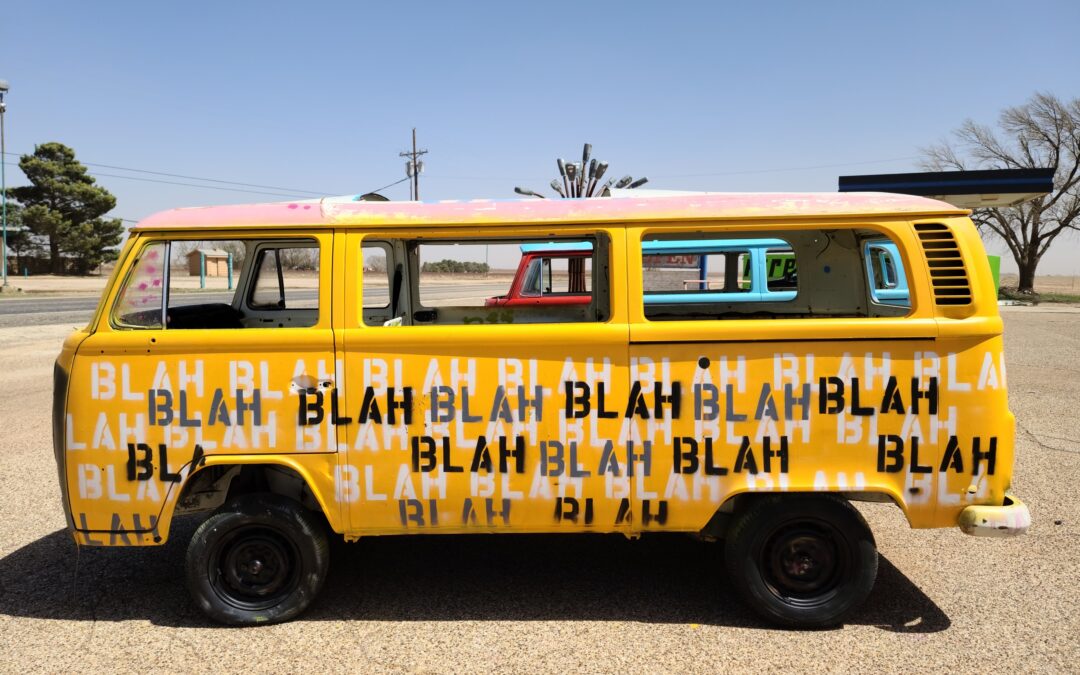 Yellow VW bus with the word "blah" written all over it