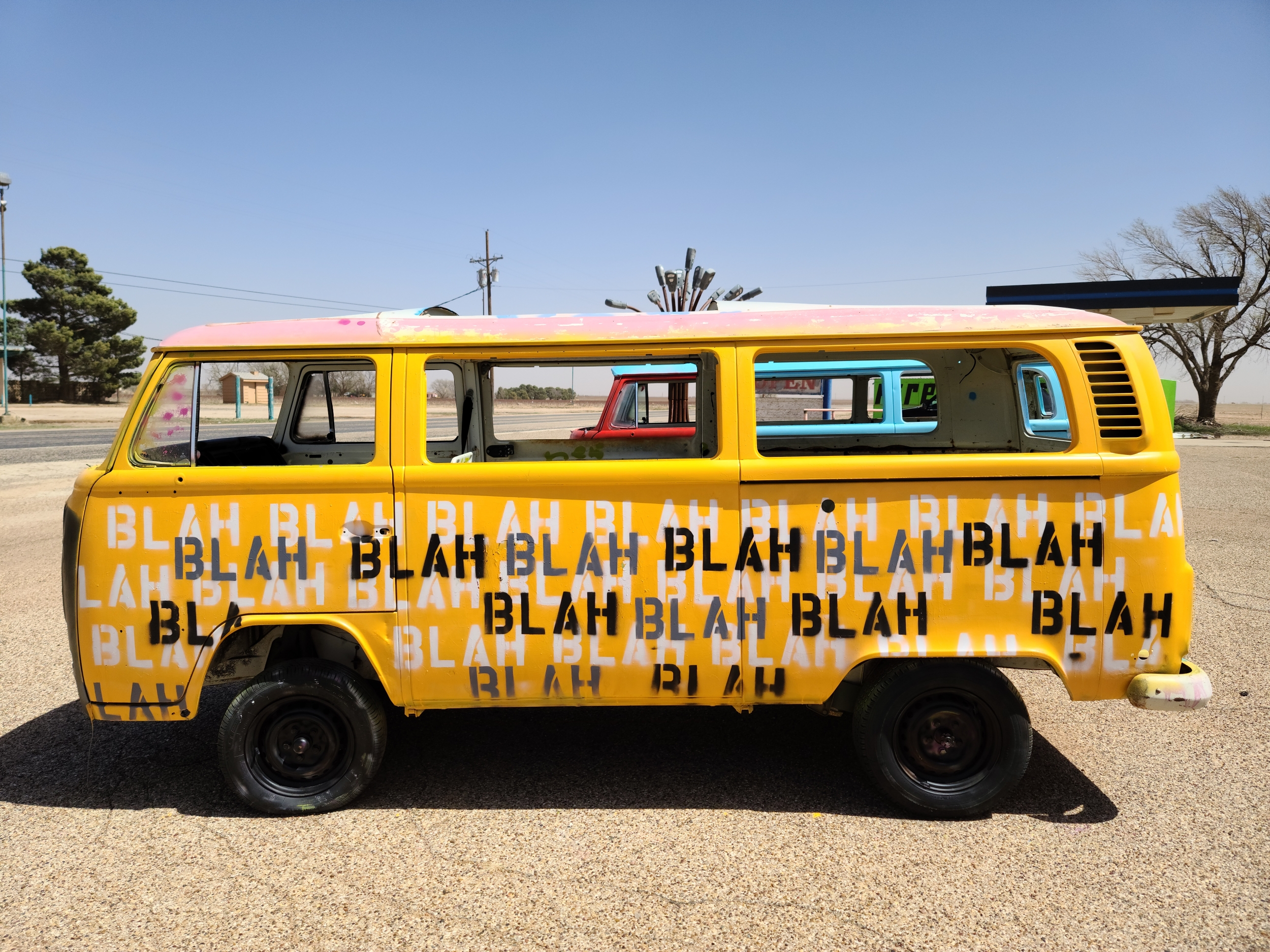 Yellow VW bus with the word "blah" written all over it