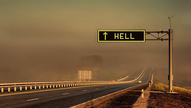 Highway leading into a smoky destination with "hell" printed on a freeway sign