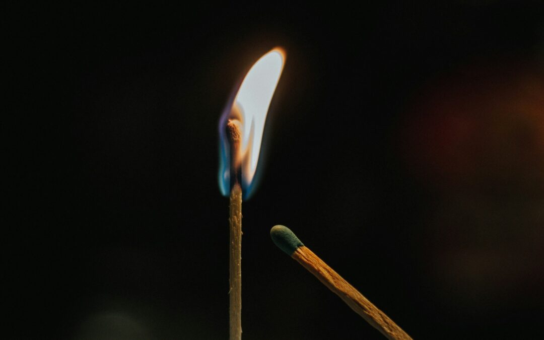 An unlit match leaning towards a lit match