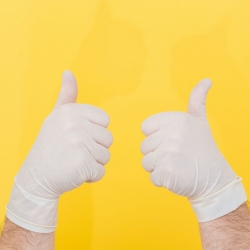 Healthcare - cropped and resized Two hands wearing medical gloves giving thumbs up